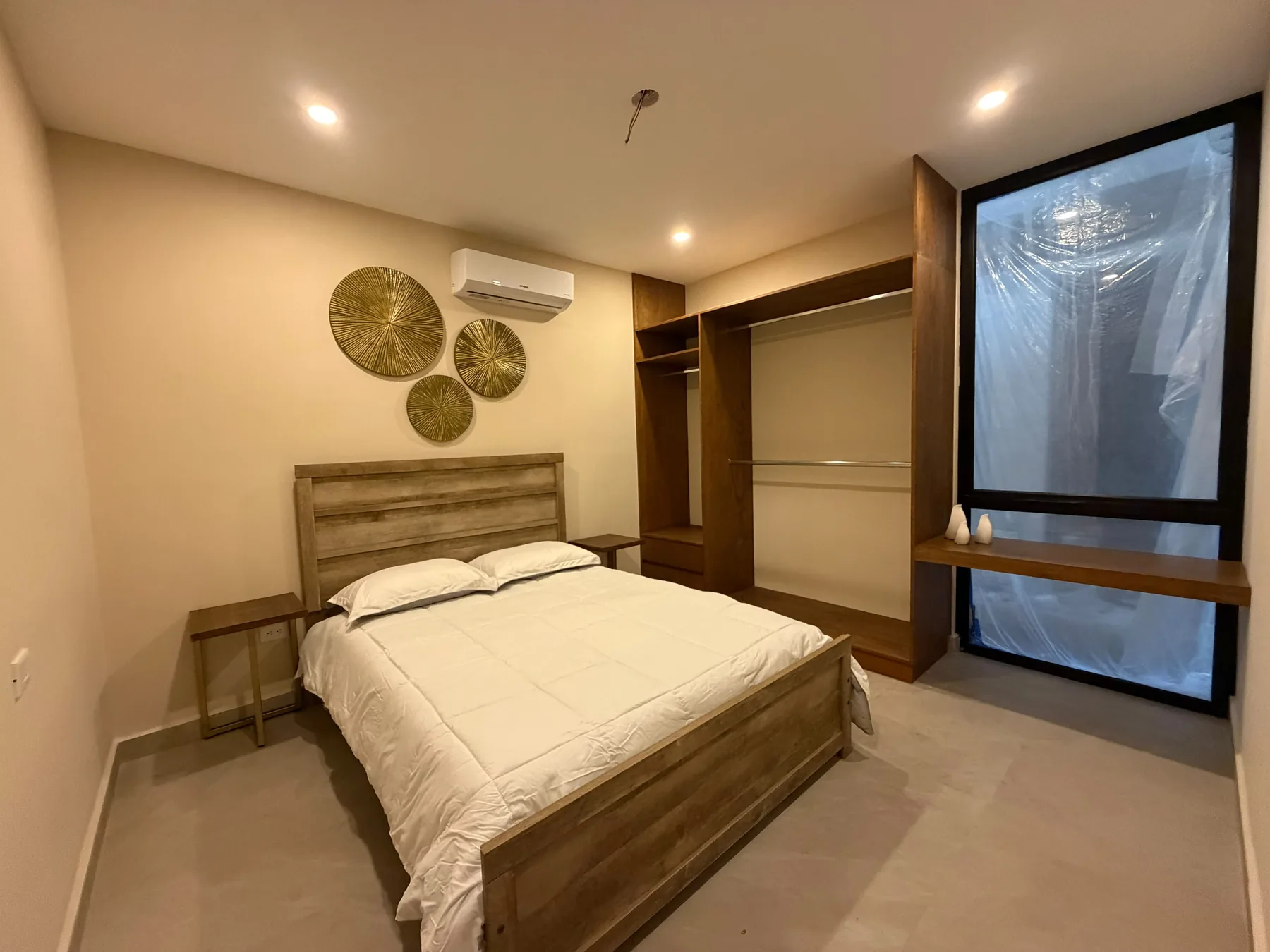 Fotografía real de la recámara del departamento muestra de Alma Condos, con cama, carpintería y ventanal.