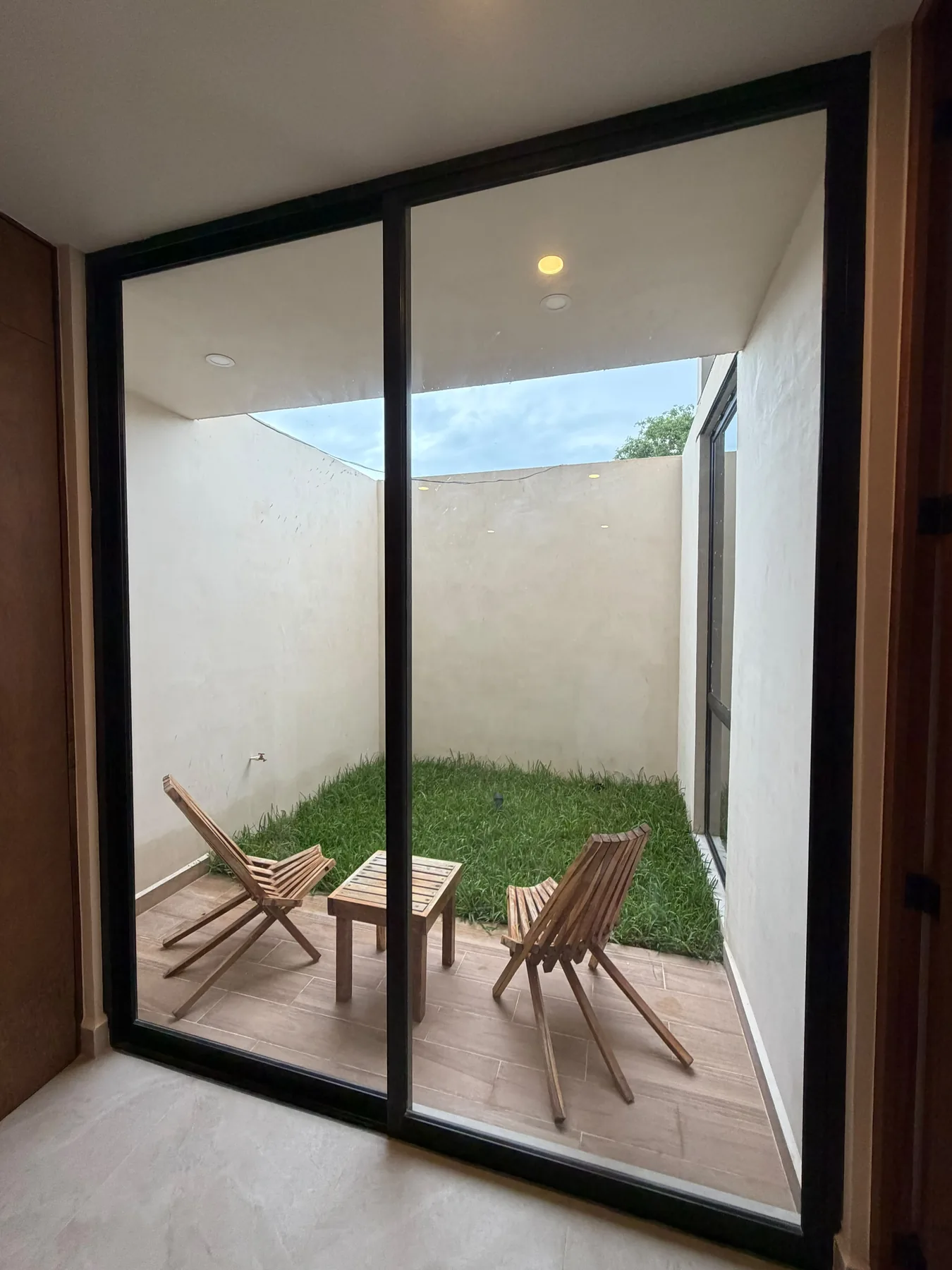 Fotografía real de la salida hacia la terraza de una unidad de planta baja del departamento muestra de Alma Condos.